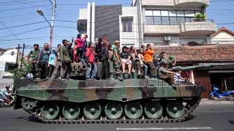 TNI AD bersama masyarakat mengikuti Pawai Kendaraan Tempur dengan menaiki Tank Leopard saat melintas di Jl. Mataram, Yogyakarta, Sabtu (11/10). [Antara/Noveradika]