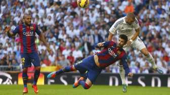 Bek Barcelona Gerard Pique (kanan bawah) bertarung memperebutkan bola dengan Karim Benzema [Reuters/Sergio Perez]