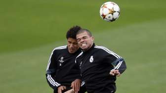 Dua bek Real Madrid Raphael Varane (kiri) dan Pepe berebut bola di udara saat sesi latihan di Valdebebas, Senin (3/11) sebelum menghadapi Liverpool di Liga Champions. REUTERS/Sergio Perez.