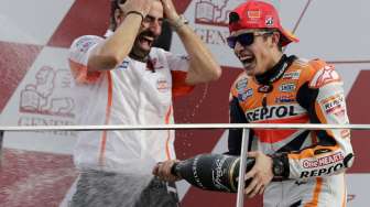 Marc Marquez melakukan selebrasi kemenangan usai menjuarai balapan terakhir musim 2014 di Sirkuit Ricardo Tormo, Spanyol, (9/11). (Reuters/Heino Kalis)