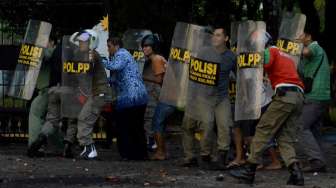 Sejumlah Satpol PP dan PNS berlindung dari lemparan batu saat demo menolak kenaikan harga BBM di Makassar, Senin (17/11). [Sahrul Manda Tikupadang]