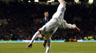 Striker Inggris Wayne Rooney melakukan selebrasi dengan bersalto merayakan golnya keduanya ke gawang Skotlandia.(REUTERS/Russell Cheyne)