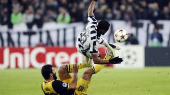 Pemain Juventus Patrice Evra (atas) berebut bola dengan Arda Turan [Reuters/Giorgio Perottino]