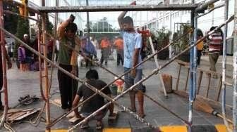 Sejumlah pekerja tampak sibuk melakukan berbagai pekerjaan renovasi di Stasiun Senen, Jakarta, Sabtu (20/12/2014). [Suara.com/Oke Atmaja]