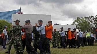Empat peti jenazah korban AirAsia diterbangkan ke Surabaya dari Lanud Pangkalan Bun, Kalteng, Kamis (1/1). [suara.com/Kurniawan Mas'ud]