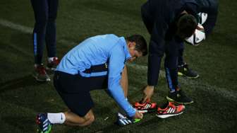 Pemain depan Spanyol memakai sepatu bola sebelum berlatih di tempat latihan Atletico Madrid di Majadahonda, dekat kota Madrid. REUTERS/Susana Vera