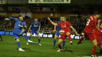 Pemain AFC Wimbledon Sean Rigg (kiri) melepaskan tendangan namun gagal masuk gawang Liverpool.REUTERS/Stefan Wermuth