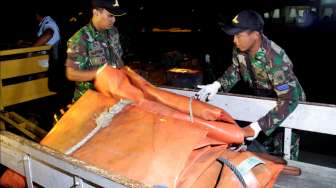 Sejumlah penyelam TNI AL menurunkan lifting bag atau balon besar yang akan difungsikan mengangkat ekor pesawat AirAsia QZ8501, di Lanud Iskandar, Pangkalan Bun, Kalteng, Kamis (8/1/2015) malam. [Antara/Suryanto]