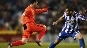 Pemain Deportivo de la Coruna's Alberto Lopo (kanan) mencoba menjegal laju Lionel Messi. REUTERS/Miguel Vidal (SPAIN - Tags: SPORT SOCCER)