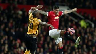 Bek Manchester United Marcos Rojo merebut bola di udara dan coba dihalangi pemain Cambridge Tom Elliott. REUTERS/Phil Noble