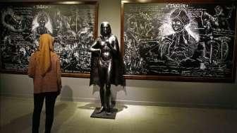 Sejumlah pengunjung menyimak karya-karya dalam pameran bertema 'Aku Diponegoro', di Galeri Nasional Indonesia, Jakarta, Kamis (8/2/2015). Ajang ini dibuka gratis untuk publik hingga 8 Maret 2015. [Suara.com/Kurniawan Mas'ud]