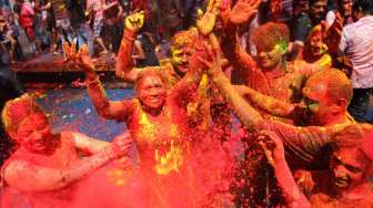 Sekelompok warga dengan tubuh penuh baluran warna, menari sambil bergembira saat merayakan Holi alias Festival Warna, di Mumbai, India, Jumat (6/3/2015). [Reuters/Shailesh Andrade]