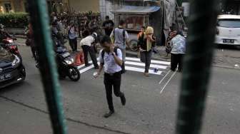 Aktivis dari kelompok Koalisi Pejalan Kaki membuat zebra cross di depan Stasiun Sudirman Jakarta, Jumat (13/3). (Suara.com/Kurniawan Mas'ud)