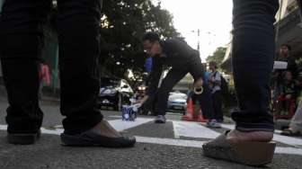 Aktivis dari kelompok Koalisi Pejalan Kaki membuat zebra cross di depan Stasiun Sudirman Jakarta, Jumat (13/3). (Suara.com/Kurniawan Mas'ud)