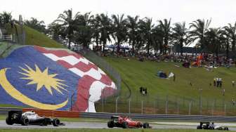 Para pebalap Formula 1 beraksi di bawah terik matahari pada ajang Formula 1 Malaysia di Sirkuit Sepang, Minggu (29/3).