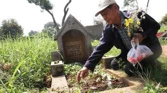 Sejumlah umat Kristiani tampak berdoa sembari membersihkan makam keluarga dan kerabatnya di beberapa TPU di Jakarta, pada momen Paskah, Minggu (5/4/2015). [Suara.com/Oke Atmaja]