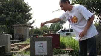 Sejumlah umat Kristiani tampak berdoa sembari membersihkan makam keluarga dan kerabatnya di beberapa TPU di Jakarta, pada momen Paskah, Minggu (5/4/2015). [Suara.com/Oke Atmaja]