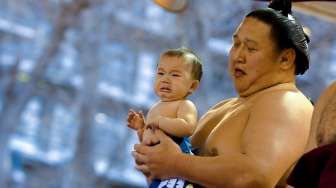 Para pesumo berkumpul di Kuil Yasukuni, Tokyo, Jepang, Jumat (3/4/2015). Para lelaki bertubuh besar yang hanya mengenakan celana ini ambil bagian dalam turnamen Sumo bertajuk Honozumo. [Reuters/Thomas Peter]