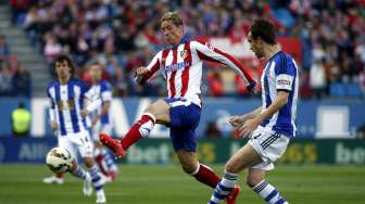 Pemain Atletico Madrid Fernando Torres (tengah) bertarung berebut bola dengan pemain Real Sociedad di Vicente Calderon (8/4). REUTERS/Susana Vera