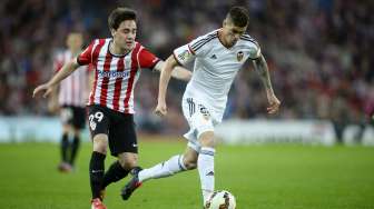 Pemain Valencia Rodrigo de Paul (R) yang sedang membawa bola dibayangi pemain Athletic Bilbao Markel Etxeberria (9/4). [Reuters/Vincent West]