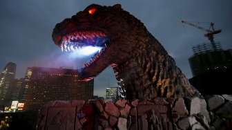 Sebuah replika kepala monster di film fiksi ilmiah, Godzilla, dipamerkan di atas balkon gedung kompleks perbelanjaan baru di distrik perbelanjaan dan hiburan Kabukicho, Tokyo, Jepang, (9/4/2015). [Reuters/Issei Kato]