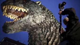 Sebuah replika kepala monster di film fiksi ilmiah, Godzilla, dipamerkan di atas balkon gedung kompleks perbelanjaan baru di distrik perbelanjaan dan hiburan Kabukicho, Tokyo, Jepang, (9/4/2015). [Reuters/Issei Kato]