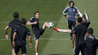 Pemain Real Madrid Gareth Bale berebut bola dengan Luka Modric (kanan) saat latihan di Valdebebas, (13/4). REUTERS/Susana Vera