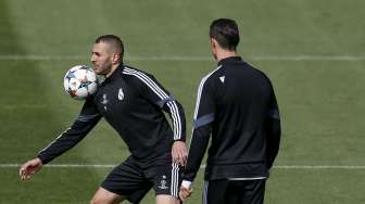 Pemain Real Madrid Cristiano Ronaldo (kanan) melihat rekan setimnya Karim Benzema mengontrol bola saat mereka latihan di Valdebebas. REUTERS/Susana Vera