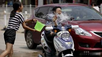 Ribuan orang ikut ambil bagian dalam festival semprot air di Xizhuangbanna, Jinghong, dan Menglian di Provinsi Yunnan, (15/4). [Reuters/Wong Campion/China Daily]