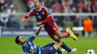 Pemain Bayern Thiago Alcantara dijatuhkan pemain Porto Ivan Marcano (21/4) [Reuters/Michael Dalder]