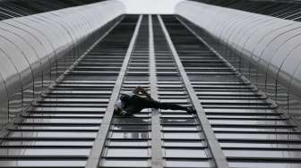 Pemanjat asal Prancis Alain Robert menaklukkan Tour Montparnasse. Gedung setinggi 210 meter di Paris, Prancis, Selasa (28/4).