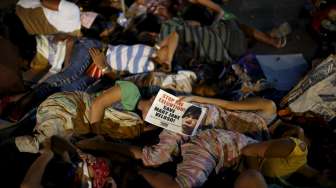 Aktivis Filipina berteriak kegirangan, berjingkrak dan berpelukan mengetahui penundaan eksekusi terhadap Mary Jane, hari Rabu (29/4/2015) dini hari di depan Kedubes Indonesia di Makati, Filipina. [Reuters/Ezra Acayan]