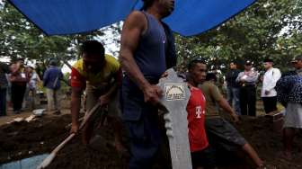 Seorang penggali makam memegang batu nisan bagi kuburan terpidana mati kasus narkoba Zaenal Abidin di sebuah pemakaman di Cilacap, Jawa Tengah, hari Rabu (29/4/2015).