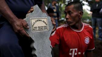 Seorang penggali makam memegang batu nisan bagi kuburan terpidana mati kasus narkoba Zaenal Abidin di sebuah pemakaman di Cilacap, Jawa Tengah, hari Rabu (29/4/2015).