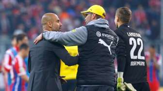 Pelatih Bayern Munich Pep Guardiola mengucapkan selamat kepada pelatih Borussia Dortmund Juergen Klopp. Reuters/Kai Pfaffenbach