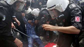 Seorang demonstran berbaring dalam sebuah bentrokan dengan polisi di Besiktas, Istanbul, Turki, tepat pada perayaan May Day (1/5).[Reuters/Murad Sezer]