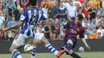 Pemain Barcelona Lionel Messi melepaskan tendangan dan coba dihalangi oleh dua pemain Real Sociedad di Camp Nou. Reuters/Gustau Nacarino