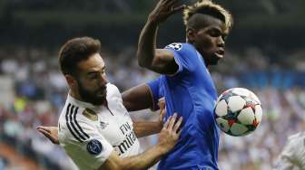 Pemain Madrid Dani Carvajal (kiri) berebut bola dengan pemain Juve Paul Pogba (14/5) [Reuters/Paul Hanna]