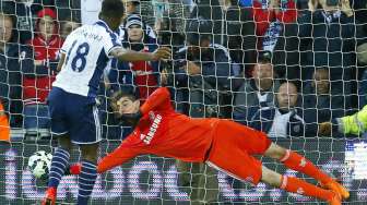 Pemain WBA Saido Berahino menjebol gawang Thibaut Courtois (19/5) [Reuters/Eddie Keogh]