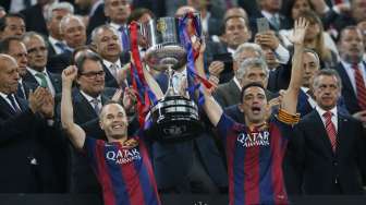 Andres Iniesta (kiri) dan Xavi Hernandez mengangkat trofi Copa del Rey (31/5) [Reuters/Albert Gea]