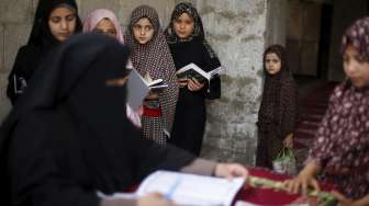 Para bocah Palestina menghafal Al Quran di sebuah masjid di Gaza City, Jalur Gaza, (7/6). Aktivitas ini dilakukan untuk mengisi liburan musim panas. [Reuters/Mohammed Salem]