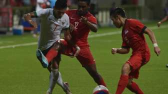 Ahmad Nufiandini (kiri) berebut bola dengan pesepak bola Singapura,Pravin Guanasagaran (tengah) dan Ho Wai Loon dalam pertandingan Sepak Bola Sea Games ke-28 di Stadion Jalan Besar, Singapura, Kamis (11/6).[Antara]