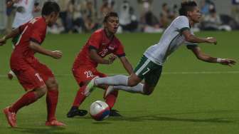 Ahmad Nufiandini (kanan) dihadang pesepak bola Singapura, Safirul Sulaiman dalam pertandingan Sepak Bola Sea Games ke-28 di Stadion Jalan Besar, Singapura, Kamis (11/6).[Antara]