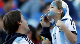 Fans Argentina sedang menghiasi wajahnya saat saat menantikan Lionel Messi dan kawan kawan menghadapi Jamaika. Reuters/David Mercado