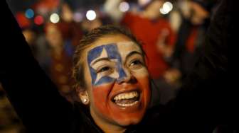 Fans perempuan Cile merayakan keberhasilan kemenangan tuan rumah atas Uruguay di Santiago (25/6). Reuters/Pablo Sanhueza