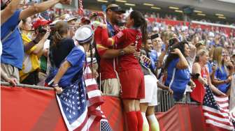 Kiper AS Hope Solo berbagi kegembiraan dengan suaminya, Jerramy Stevens, yang hadir langsung untuk memberi dukungan (6/7) [Reuters]