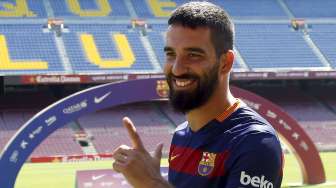 Pemain baru Barcelona Arda Turan saat diperkenalkan kepada publik di Camp Nou (10/7). Reuters/Gustau Nacarino