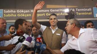 Robin van Persie menyapa para suporter Fenerbahce yang menyambutnya di bandara  Sabiha Gokcan, saat tiba di Istanbul, Turki (12/7). Reuters/Osman Orsal.