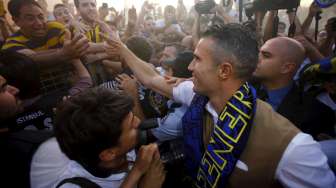 Robin van Persie menyapa para suporter Fenerbahce yang menyambutnya di bandara  Sabiha Gokcan, saat tiba di Istanbul, Turki (12/7). Reuters/Osman Orsal.