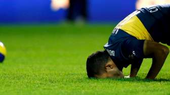 Carlos Tevez mencium rumput La Bombonera stadium saat diperkenalkan sebagai pemain baru Boca Juniors (14/7). Reuters/Marcos Brindicci